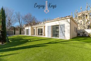 une maison avec une pelouse verte devant elle dans l'établissement Maison au cœur de la ville, à Salon-de-Provence