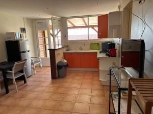 une cuisine avec des appareils rouges et blancs et une table dans l'établissement Ocean bleu 972 Orange N 2, à Les Anses-d'Arlet