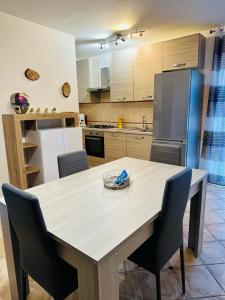 eine Küche mit einem Tisch mit Stühlen und einem Kühlschrank in der Unterkunft Appartamento accogliente con terrazzo panoramico in Telese