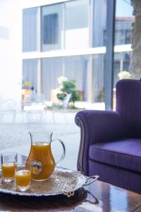ラルナカにあるLokàl Boutique Hotelのオレンジジュースのグラスピッチャー