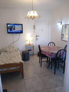 ein Zimmer mit Tisch und Stühlen und einem Fernseher in der Unterkunft Depto frente a Shopping Aldrey in Mar del Plata