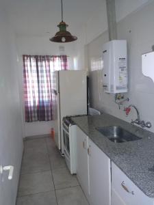 eine Küche mit Spüle und einem weißen Kühlschrank in der Unterkunft Depto frente a Shopping Aldrey in Mar del Plata
