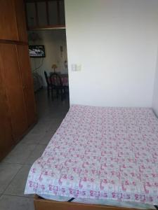 ein Schlafzimmer mit einem Bett mit einer rosa-weißen Steppdecke in der Unterkunft Depto frente a Shopping Aldrey in Mar del Plata + 4 Fotos