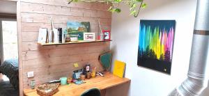 einen Schreibtisch in einem Zimmer mit einer Holzwand in der Unterkunft La Mélisse in Saint-Félix-de-Rieutort + 28 Fotos