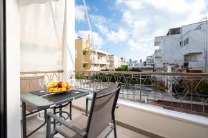 a balcony with a table with a bowl of fruit on it at Coastal Elegance Suite 1-Min to the Beach in Ampavris