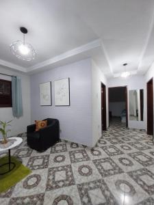 a living room with a couch and a table at Casa ampla com Wi-Fi e garagem para dois veículos in Campos dos Goytacazes