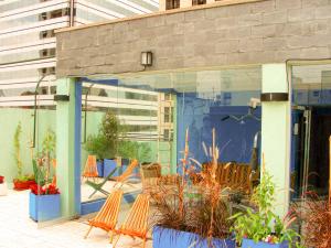 um edifício de vidro com cadeiras e plantas em Moreno 820 Design Apartments em Buenos Aires