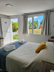 a bedroom with two beds and a large window at Alameda Apart in El Calafate