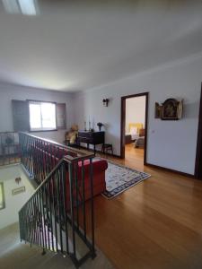 a living room with a red couch and a staircase at Casa Maria Joana in Ponte de Lima