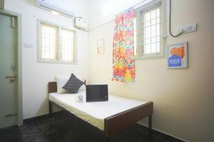 um quarto com uma cama com um computador portátil em Frankfurt Livings em Chennai