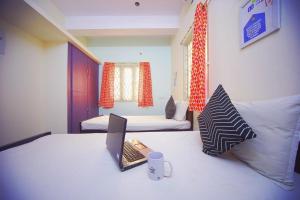 um quarto com uma cama com um computador portátil em Frankfurt Livings em Chennai