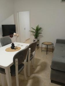 sala de estar con mesa blanca y sillas en ViVo Beach Apartment, en Durrës