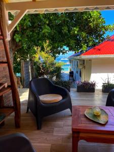 a living room with a chair and a table at Villa KER IGUANE Terre de Haut Les saintes in Terre-de-Haut