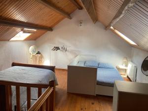 a bedroom with two beds in a attic at Maison au calme a l'orée du bois. Accès A13-A14 in Orgeval