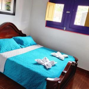 a bedroom with a bed with two towels on it at Hostal Palmas De Cocora in Salento
