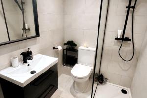 a bathroom with a shower and a toilet and a sink at Chic, Relaxing stay just 18 mins into the City in London