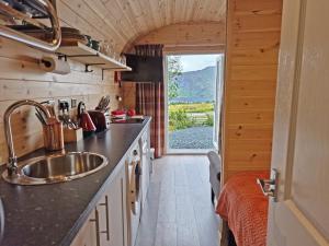 a kitchen with a sink and a large window at Rowan Gorgeous Glamping Hideaway in Durnamuck