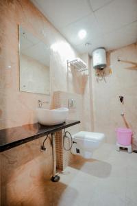 a bathroom with a sink and a toilet at Hotel Pinkcity Prime & Chicago View Cafe in Jaipur