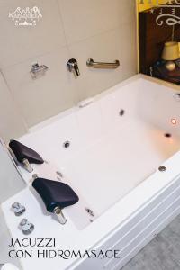 a white bath tub with two faucets on it at Hotel Kapadokya in Huánuco