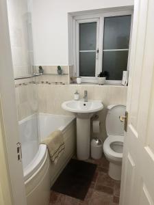 a bathroom with a tub sink and a toilet at Princess Wigan House in Wigan +29 photos