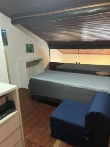 une chambre avec deux lits et un pouf bleu dans l'établissement Winterville Gravatá Lazer e descanso!, à Gravatá