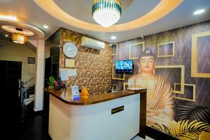 a restaurant counter with a large painting of a statue at Hotel Pinkcity Prime & Chicago View Cafe in Jaipur