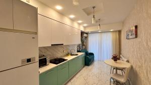 uma cozinha com armários verdes e uma mesa num quarto em Azure Residence em Baku