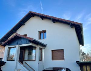 a white house with a black roof at Appartement 4 à 6 pers Annecy in Annecy