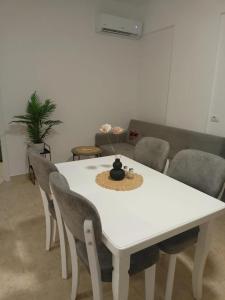 una mesa blanca y sillas en la sala de estar. en ViVo Beach Apartment, en Durrës