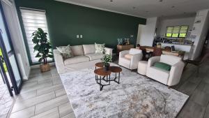 una sala de estar con sofás blancos y una mesa. en KRJSA Townhouse -Bryanston, en Johannesburgo
