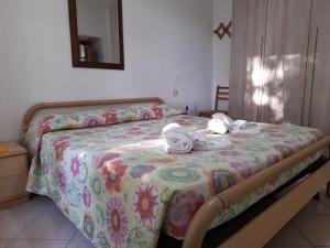 um quarto com uma cama com toalhas em 8380 Morellino little house em Montemerano