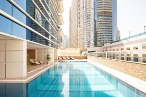 Marina Two Bedroom With Balcony - KV Hotels في دبي: مسبح فوق مبنى ذو مباني طويلة