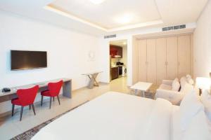 Marina Studio - KV Hotels في دبي: غرفة معيشة مع أريكة وكراسي حمراء