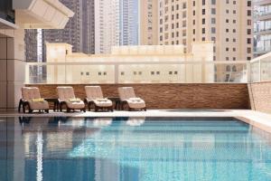 Marina Studio - KV Hotels في دبي: جلسة مجموعة كراسي بجانب المسبح