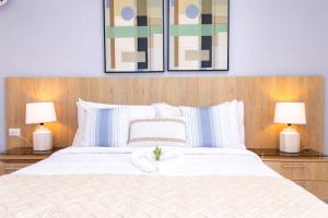 1 dormitorio con 1 cama blanca grande y 2 lámparas en Habana Hotel Y Restaurante, en Higüey