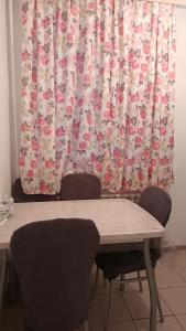 uma mesa e cadeiras em frente a uma cortina em 3-х комнатная квартира в Павлодаре em Pavlodar