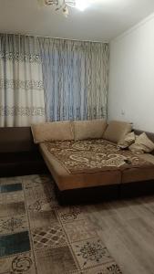 un letto in una stanza con tende e un pavimento di 3-х комнатная квартира в Павлодаре a Pavlodar