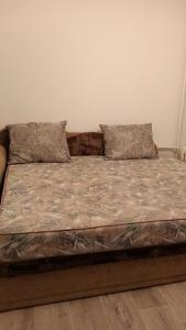 uma cama com duas almofadas em cima em 3-х комнатная квартира в Павлодаре em Pavlodar