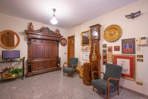 een woonkamer met een grootvaders klok en twee stoelen bij Residenza Impero Bezzecca in Verona