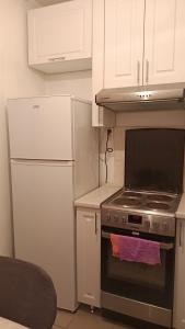 Il comprend une cuisine équipée d'une cuisinière et d'un réfrigérateur. dans l'établissement 3-х комнатная квартира в Павлодаре, à Pavlodar