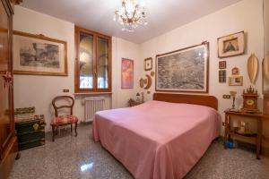 een slaapkamer met een roze bed en een stoel bij Residenza Impero Bezzecca in Verona