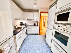 a white kitchen with white cabinets and appliances at Excellent Entire Apartment Between St Pauls Cathedral and Covent Garden in London