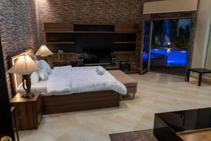 1 dormitorio con 1 cama grande y TV en فيلا كامله للايجار اليومي, en Medina