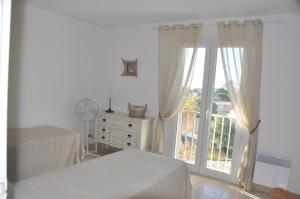 a white room with a bed and a window at Arc en ciel, vue mer et piscine dans résidence in Saint Pierre La Mer