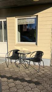 2 chaises et une table devant une fenêtre dans l'établissement Hyggelig lejlighed i Rinkenæs, à Gråsten