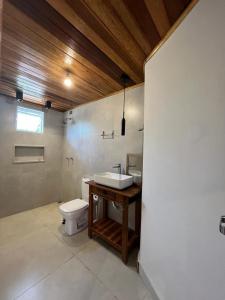 uma casa de banho com um lavatório e um WC em Pousada Vila Margarida em Chapada dos Guimarães