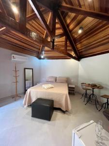 a bedroom with a large bed and a table at Pousada Vila Margarida in Chapada dos Guimarães