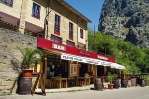 un bar con mesas y sillas fuera de un edificio en Arcea Mirador de Cabrales en Poncebos