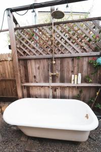 a bath tub sitting in front of a wooden fence at TinyHome at the Sanctuary in Lakeside +52 photos