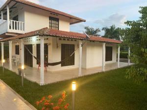 a white house with lights in the yard at Casa descanso Mariquita in Mariquita